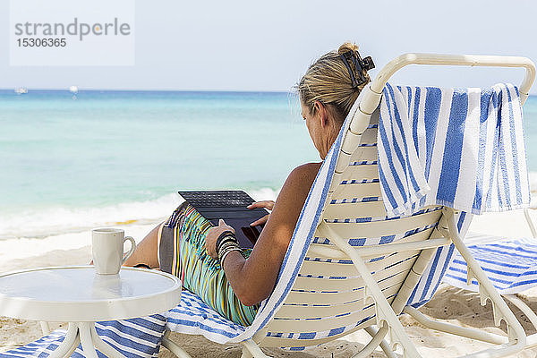 erwachsene weibliche Führungskraft mit Smartphone am Strand