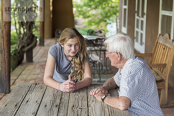 Ein Mädchen im Teenageralter im Gespräch mit ihrem Großvater