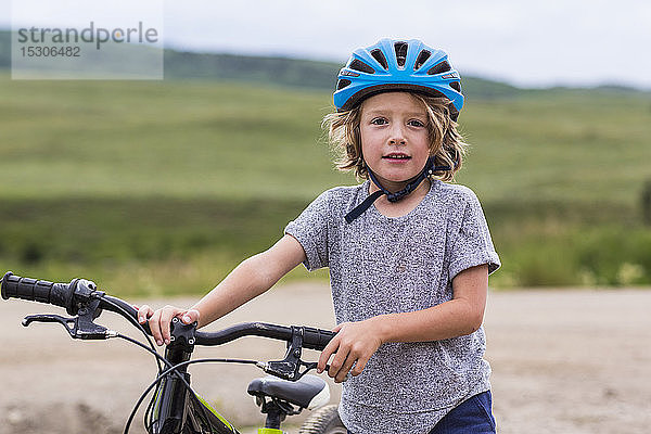 Porträt eines 5-jährigen Jungen  der sein Mountainbike hält