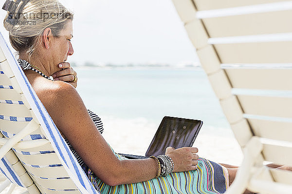 erwachsene weibliche Führungskraft mit Laptop am Strand