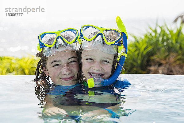 Ein junges Mädchen und ihr 5-jähriger Bruder im Schwimmbad  lächelnd