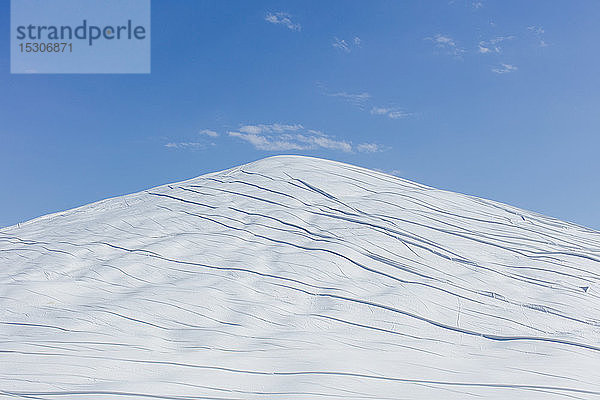 Dunghaufen mit weißer Plane bedeckt  vor blauem Himmel.