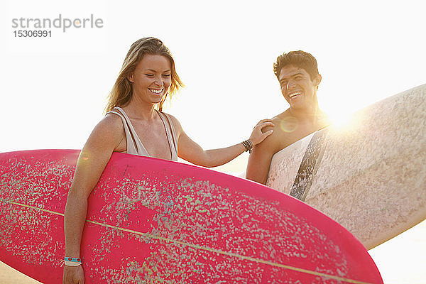 Glückliches junges Paar mit Surfbrettern