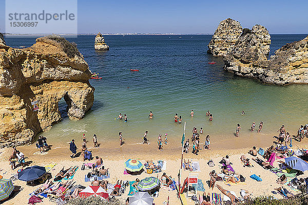 Touristen beim Sonnenbaden und Schwimmen am sonnigen Sommerstrand  Lagos  Algarve  Portugal