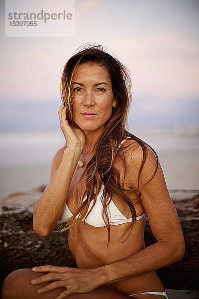 Porträt selbstbewusste Frau im Bikini am Strand