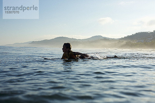 Silhouette Junge Surfer paddelt auf dem sonnigen Meer  Sayulita  Nayarit  Mexiko