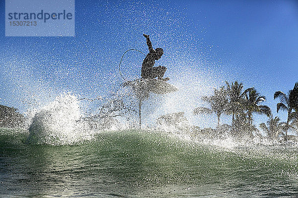 Männlicher Surfer  der über einer Meereswelle Luft holt  Sayulita  Nayarit  Mexiko