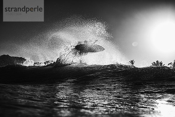 Surfer  der bei Sonnenaufgang hinter einer Welle Luft schnappt  Sayulita  Nayarit  Mexiko