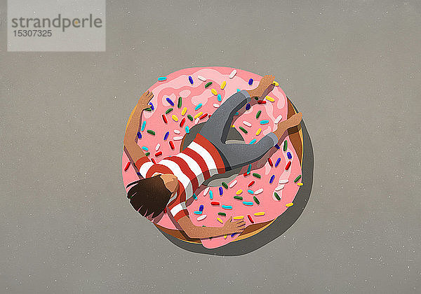 Mädchen entspannt sich auf großem Donut mit Streuseln