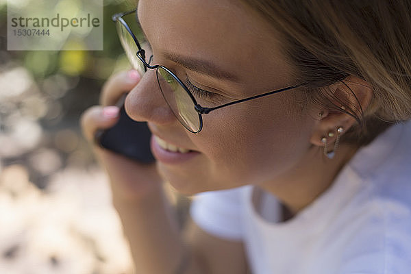 Junge Frau spricht mit einem Smartphone