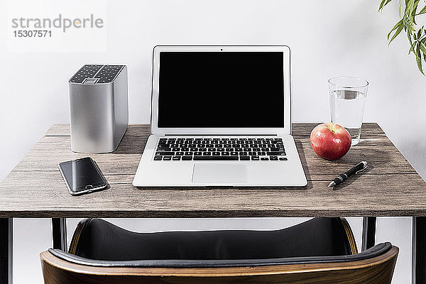 Laptop  Smartphone  Apfel  Wasser und Stift auf dem Schreibtisch