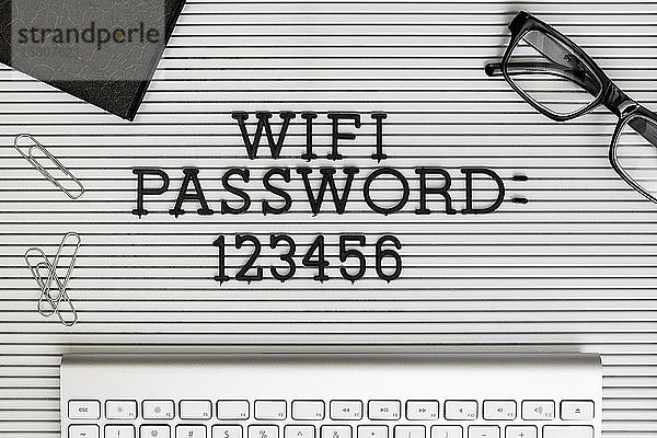 Ansicht Formular über 'Wifi Passwort 123456' auf dem Schreibtisch über der Computertastatur