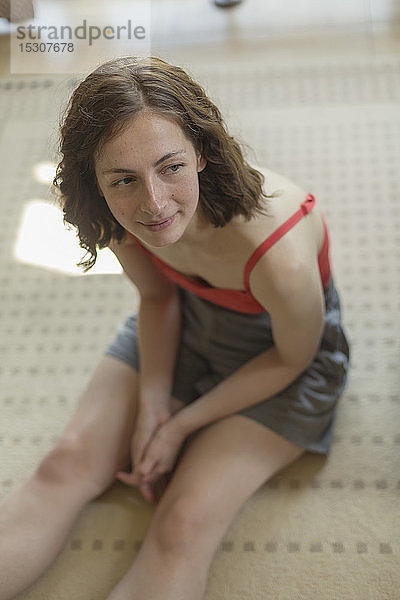 Frau entspannt sich  sitzt auf Teppich