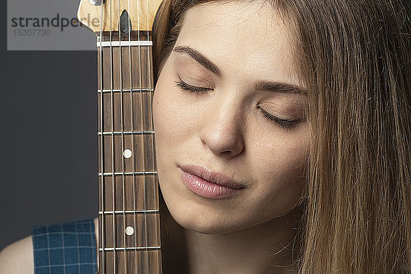 Nahaufnahme Porträt heitere junge Frau mit Gitarre