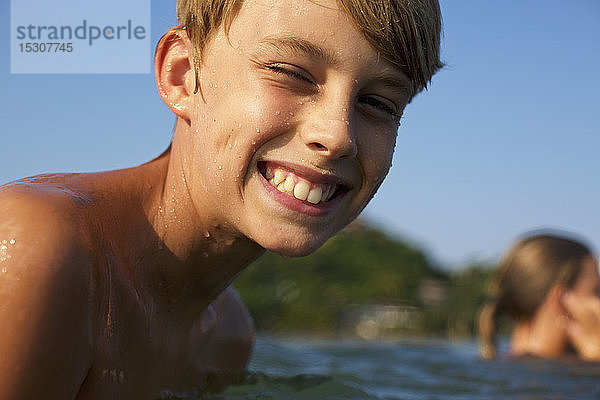 Porträt glücklicher  sorgloser Junge beim Schwimmen im See