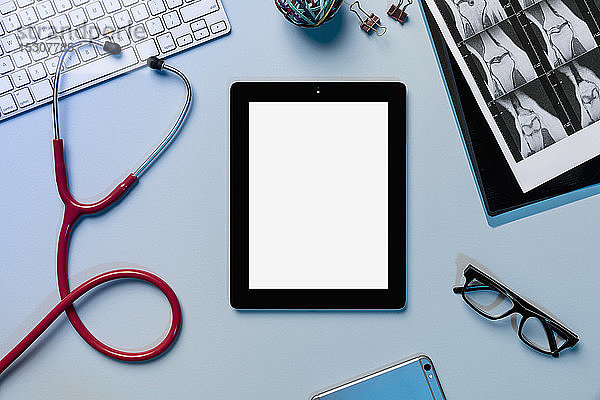 Ansicht des Formulars über dem digitalen Tablet  umgeben von Stethoskop und Röntgenstrahlen