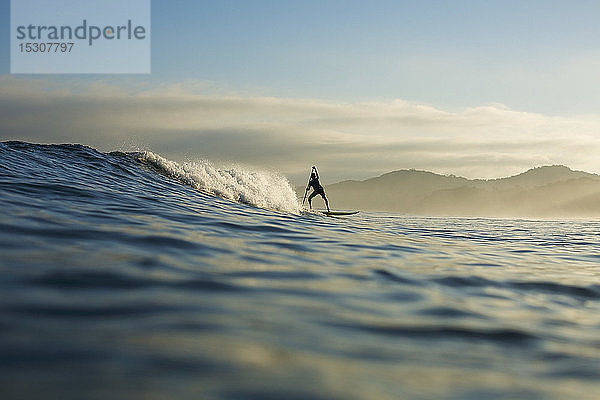 Silhouette eines Paddelboardfahrers auf einer Meereswelle  Sayulita  Nayarit  Mexiko