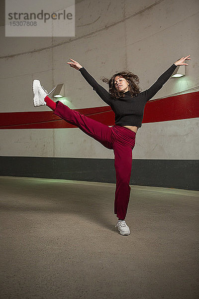 Porträt selbstbewusste junge Frau tanzt im Tunnel