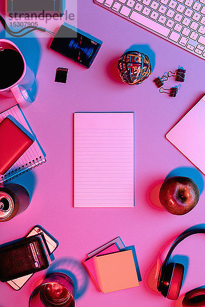 Ansicht eines Formulars über einem leeren Notizblock auf dem Schreibtisch  umgeben von Büromaterial