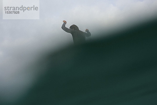 Männlicher Surfer reitet auf einer Meereswelle