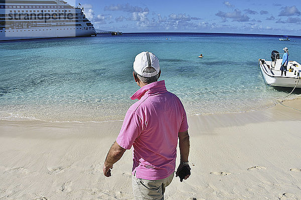 Älterer Mann spaziert am sonnigen Strand  Grand Turk Island  Turks- und Caicosinseln