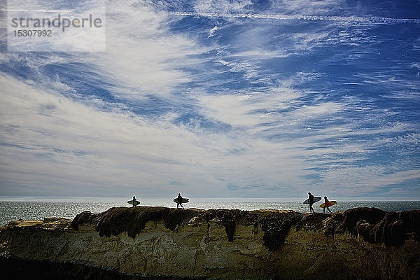 Surfer tragen Surfbretter auf Felsen im Meer  Santa Cruz  Kalifornien  USA