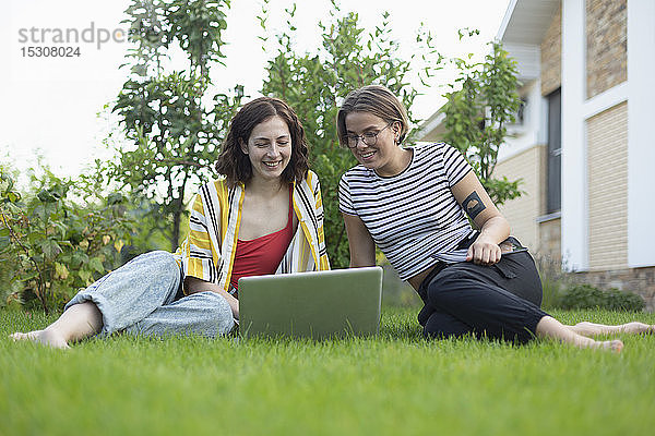 Freundinnen benutzen Laptop im Gras