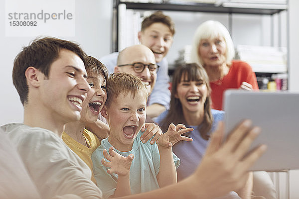 Große Familie hat Spaß zu Hause und verwendet ein digitales Tablet