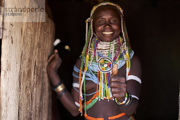 Porträt einer traditionellen Muhila-Frau  die in ihrem Haus steht und ihre Bescheidenheit aufgibt  Congolo  Angola