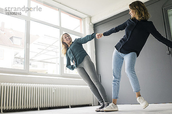 Zwei junge Frauen unterstützen sich gegenseitig spielerisch