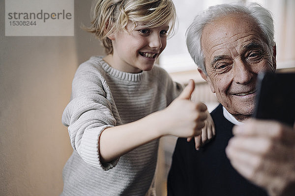 Glücklicher Großvater und Enkel  die zu Hause ein Selfie machen