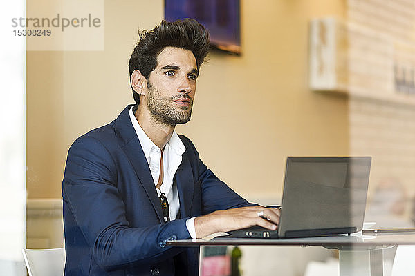 Geschäftsmann mit Laptop in einem städtischen Café