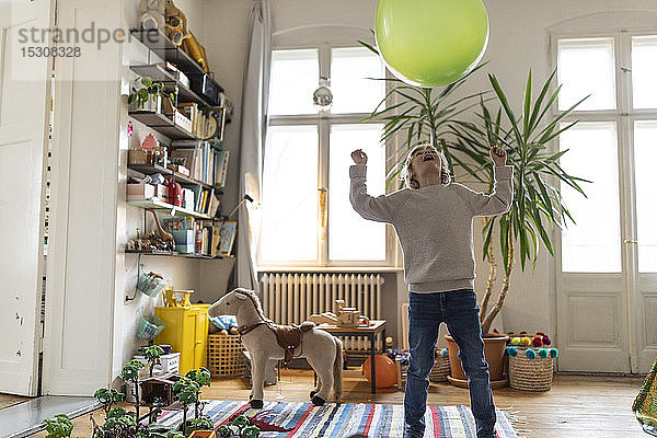 Junge spielt zu Hause mit einem Luftballon
