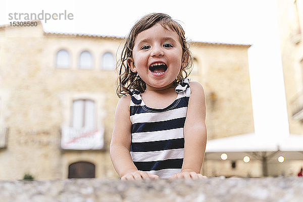 Porträt eines glücklichen kleinen Mädchens im Sommer in einem gestreiften Kleid