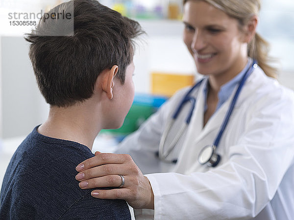Ärztin  die einem Jungen bei einem Termin in der Klinik eine Anleitung gibt