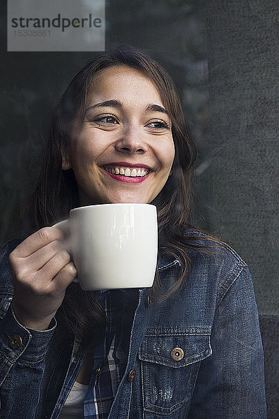 Junge Frau in Café mit Tasse Kaffee und Blick zur Seite