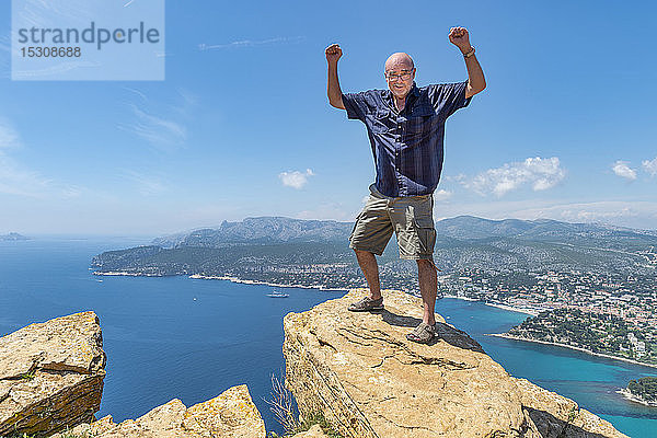 Älterer Mann auf Klippe stehend