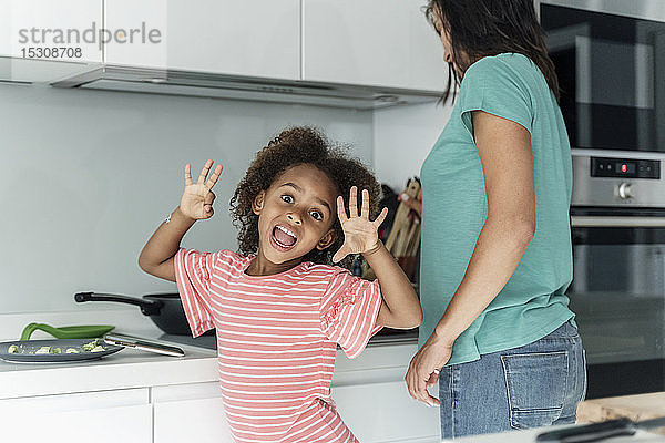 Porträt eines glücklichen Mädchens beim Kochen mit der Mutter in der Küche