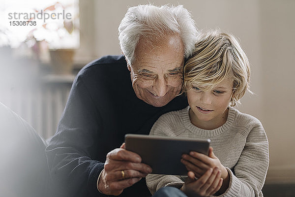 Großvater und Enkel verwenden zu Hause eine Tablette