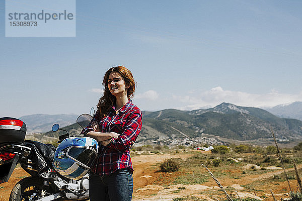 Glückliche rothaarige Frau mit Motorrad genießt Aussicht  Andalusien  Spanien