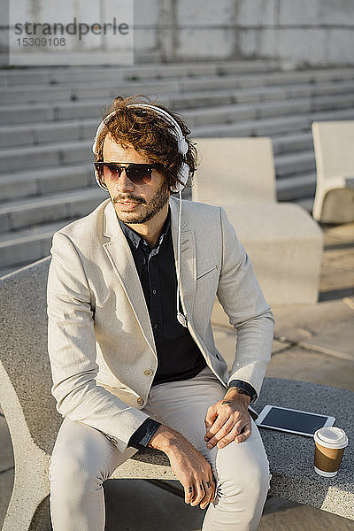 Porträt eines Geschäftsmannes mit Kopfhörer und Sonnenbrille