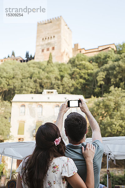 Rückansicht des Ehepaars  das die Alhambra in Granada  Spanien  fotografiert