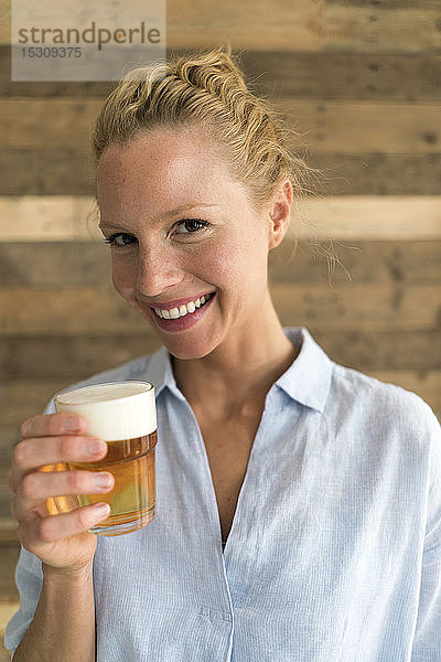 Bildnis einer blonden Frau mit einem Glas Bier