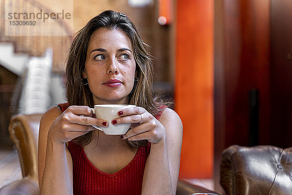 Porträt einer jungen Frau mit Tasse Kaffee
