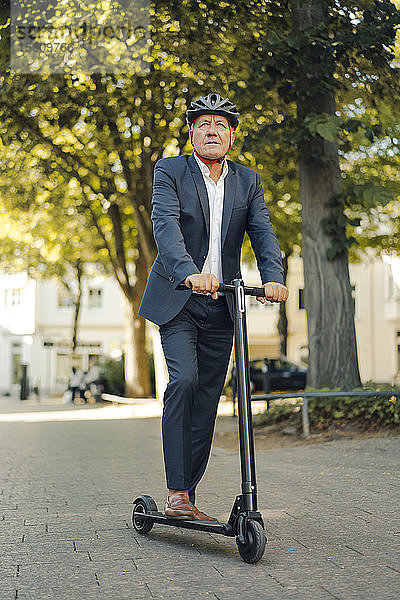 Älterer Mann fährt E-Scooter in der Stadt