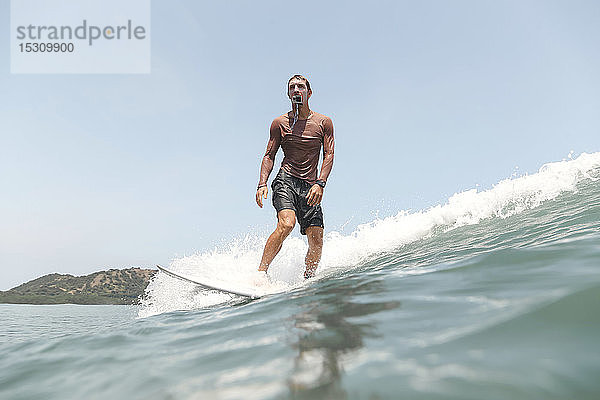 Surfer mit Aktionskamera im Mund