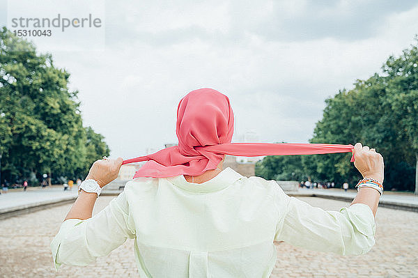 Rückansicht einer Frau mit rosa Kopftuch