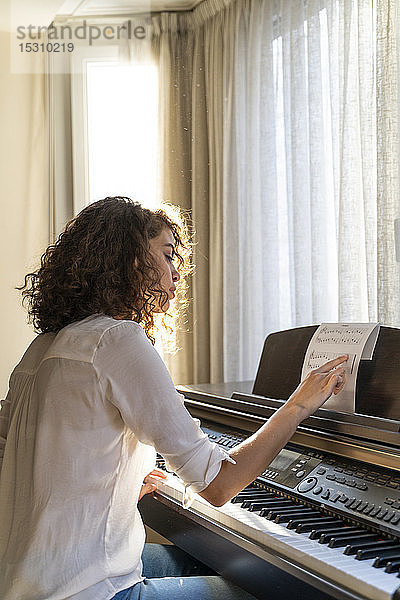 Frau spielt zu Hause Klavier
