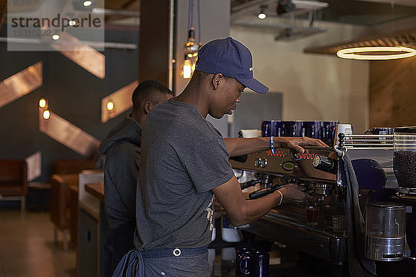 Junger Mann bereitet Kaffee im Café vor