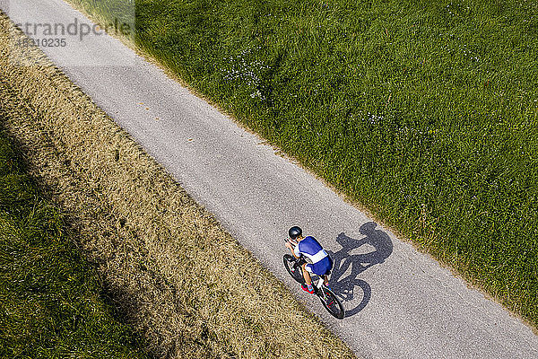 Triathlet auf dem Fahrrad auf der Landstraße  Deutschland